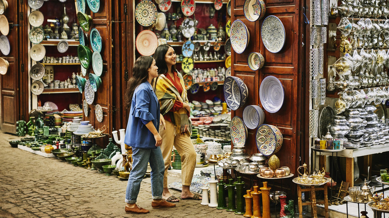 Two women outside of a pottery shop in Morocco