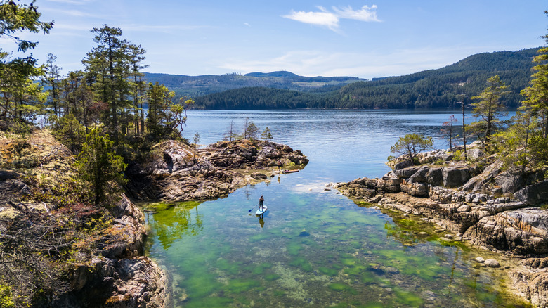 Person paddleboarding surrounded by mountains