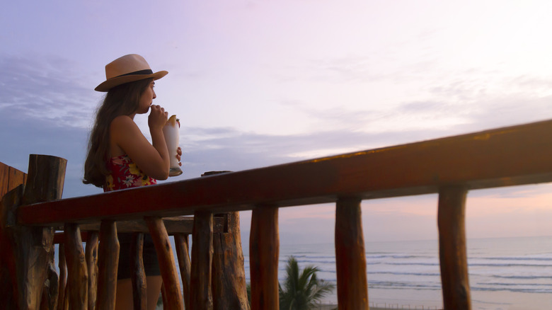 woman drinking and watching Ecuador sunset