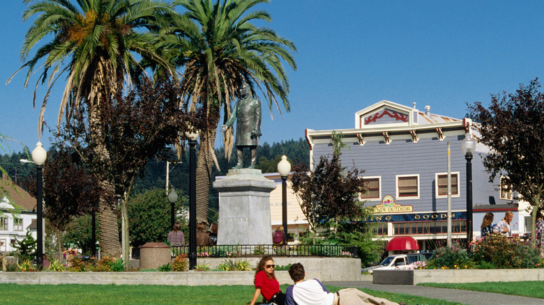 People lounging on the grass of a park square during a sunny day in Arcata