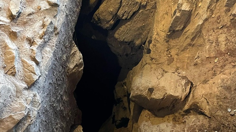 The cave wall opens onto a narrow passageway