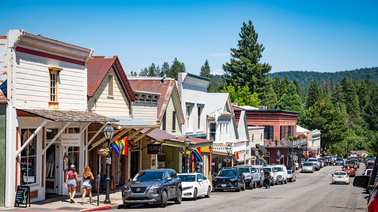 A street of shops, cars and LGBTQ+ flags in Nevada City