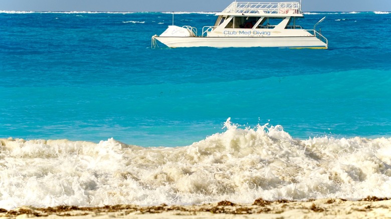 A boat cruises off the shore of Grace Bay Beach