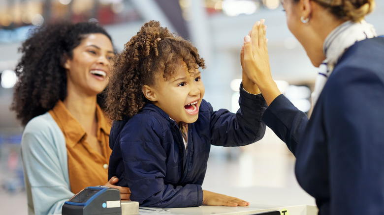 Child high-fiving flight attendant