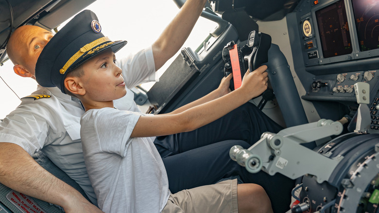 Child sitting in plane cockpit