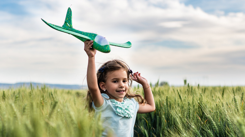 Child running with model airplane