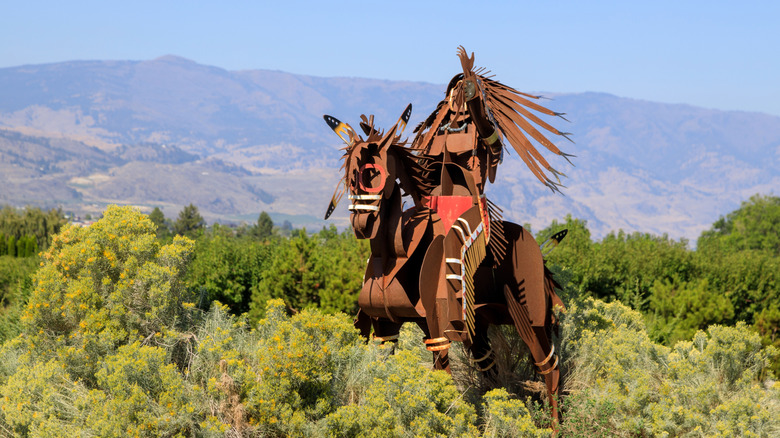 First Nations statue nestled in lush greenery at Spirit Ridge