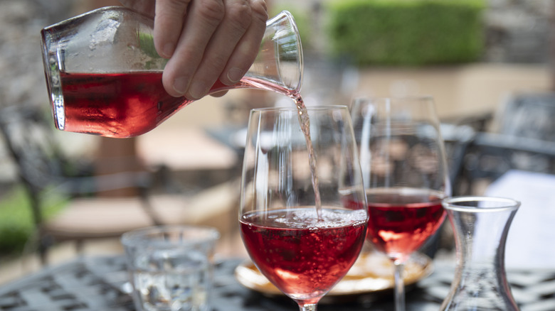 Hand pouring red wine into a glass