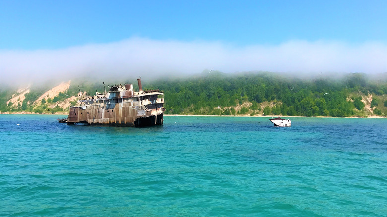 Partially sunk shipwreck off sandy beach in Lake Michigan