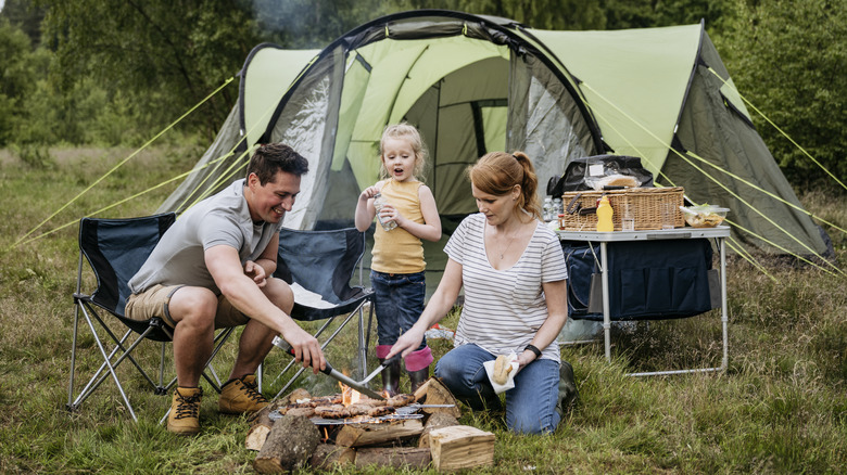 family cooking outside tent