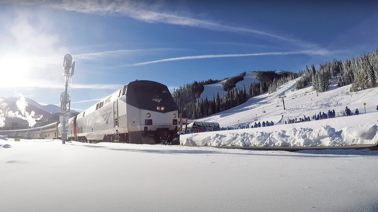 Amtrak train at Winter Park Resort station on a sunny day in snow