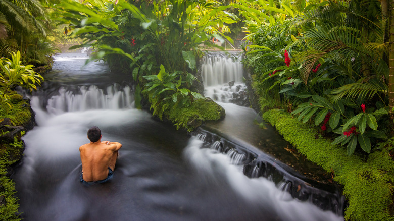 Man sitting in hot springs in La Fortuna, Costa Rica.