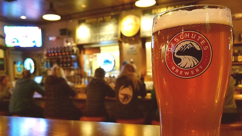 A pint glass from the Deschutes Brewery, filled with beer