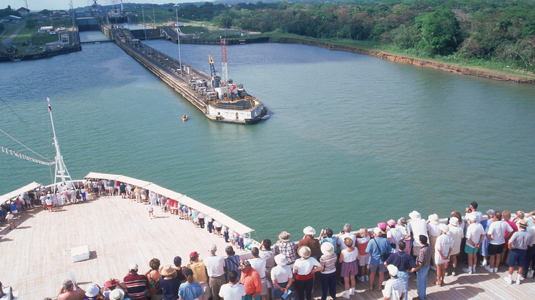 Passengers watch as their cruise ship crosses the Panama Canal