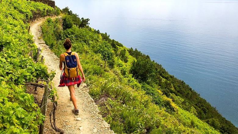 Woman walking on Cinque Terre trail next to Mediterranean sea