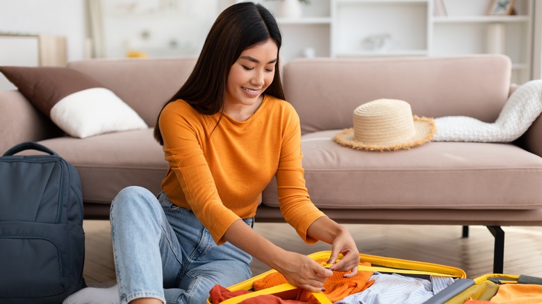 Smiling woman packing for a vacation