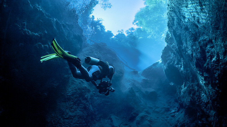 Diver swimming through Mexican cenote