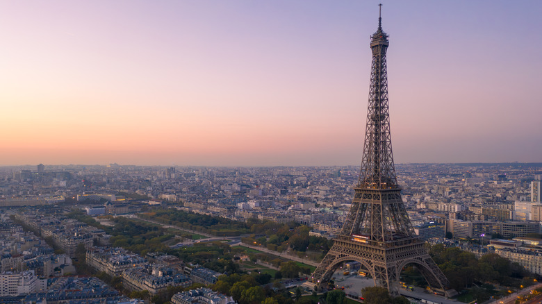 An aerial view of Paris, with the Eiffel Tower in prominent view and a sunset