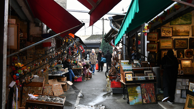 Street view of the Marché aux Puces de Saint-Ouen with several shops and wares on display