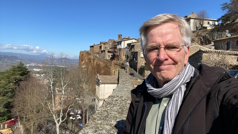 Rick Steves posing near a steep ledge in Italy