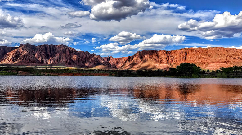 Red mountains behind a clear lake