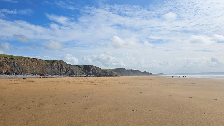 Wide sandy beach with cliffs