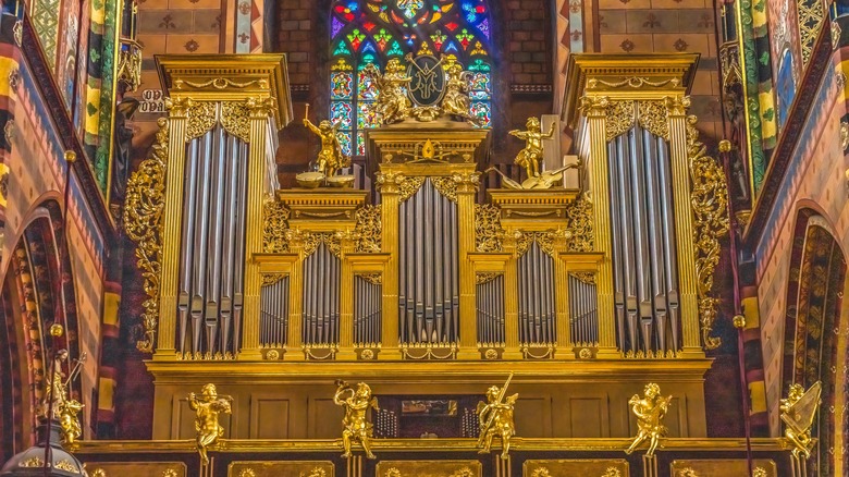 Ornate organ in front of stained glass window