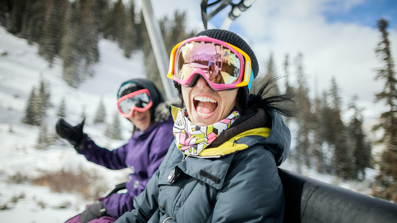 Two smiling skiers on a ski lift