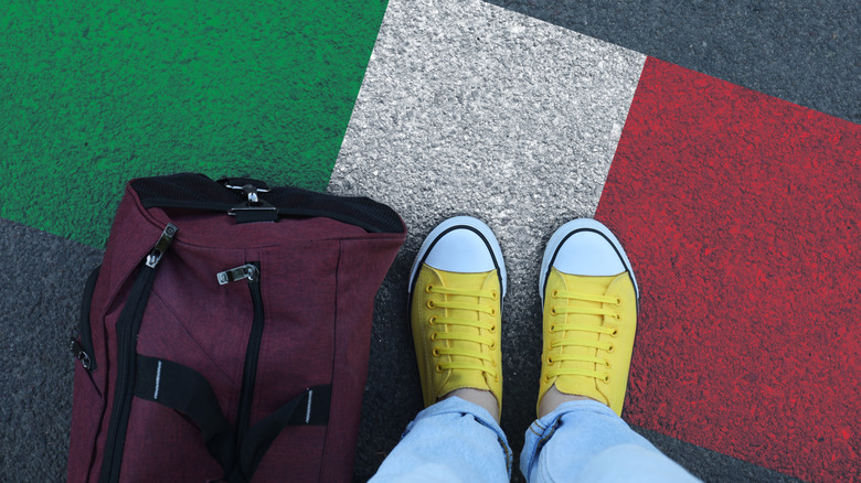 Person standing on ground painted as Italian flag