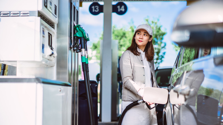 Woman filling up her car at a gas station