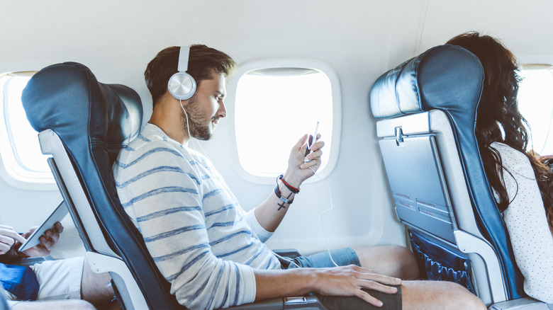 Passenger using headphones on flight