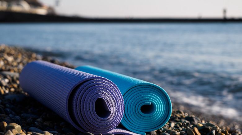 Rolled up yoga mats on the beach