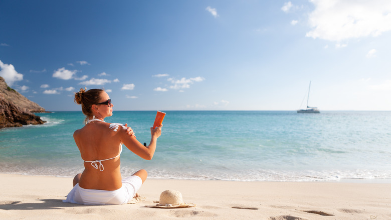 Woman applying sunscreen Caribbean beach