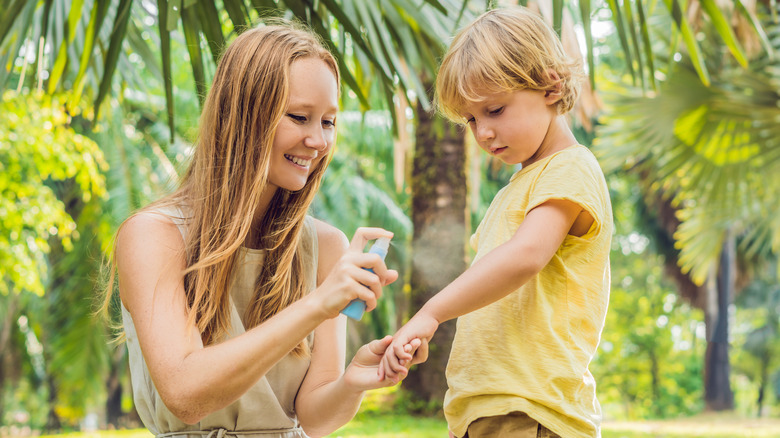 Mother applying insect repellant