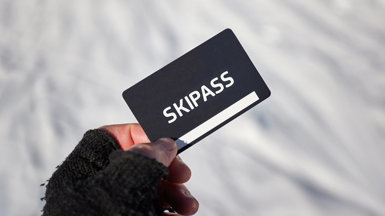 Ski pass card held in gloved hand