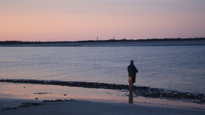 Fishing on the beach at sunset