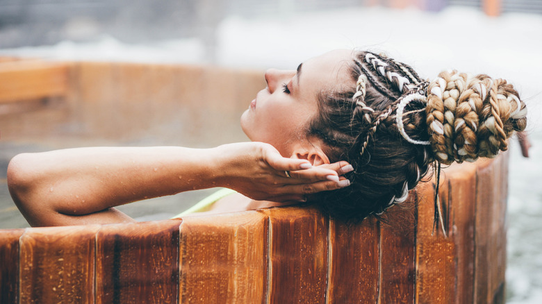 Woman relaxing in a wooden hot tub