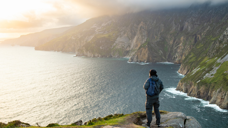 A hiker looking at the ocean view from the Slieve League Cliffs, Ireland