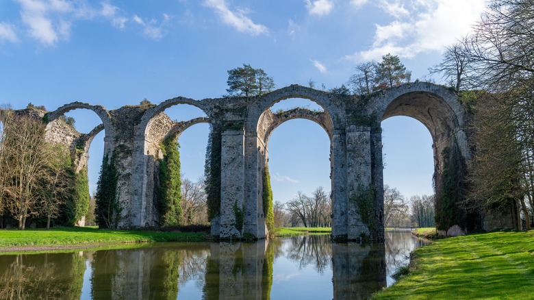 Unfinished stone aqueduct over an artificial lake