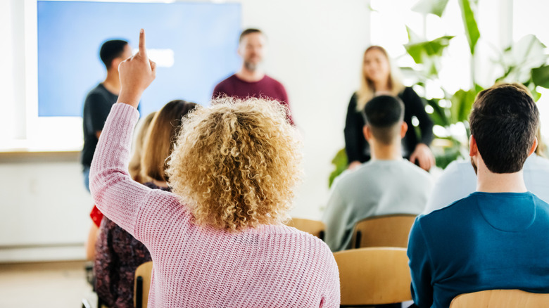 Woman raising hand to ask question