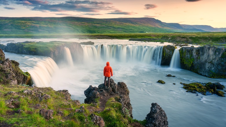 Person in waterproof jacket looking at Iceland waterfall