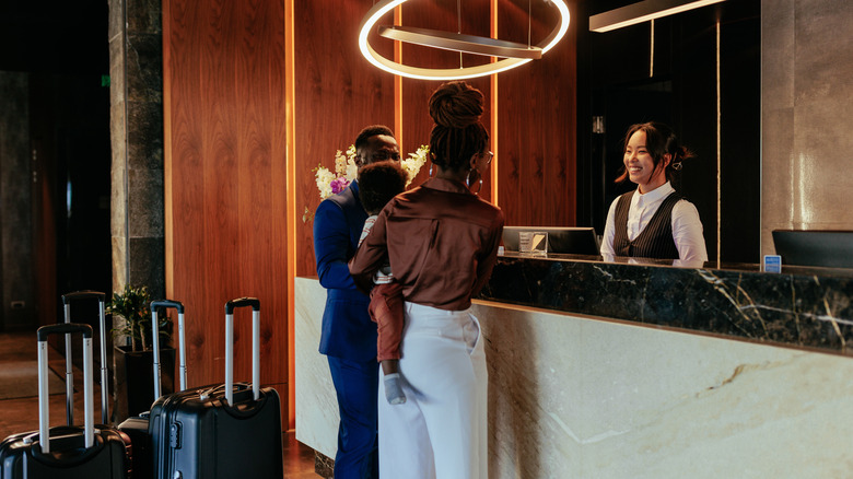a family checks out at hotel reception