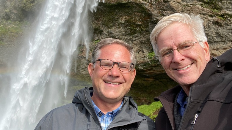 Rick Steves and Cameron Hewitt by a waterfall in Iceland