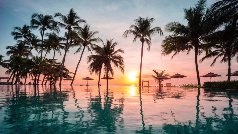 Sunset over infinity pool and ocean in Thailand