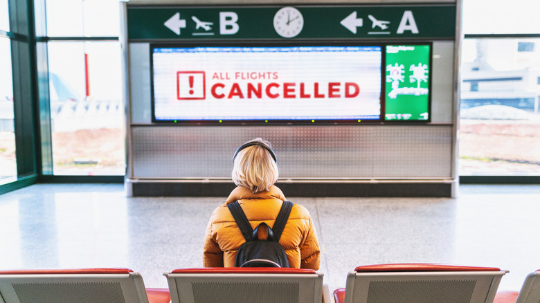 person sitting near cancelled sign