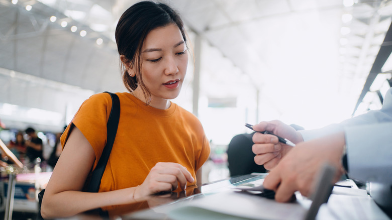 woman with paperwork at airport