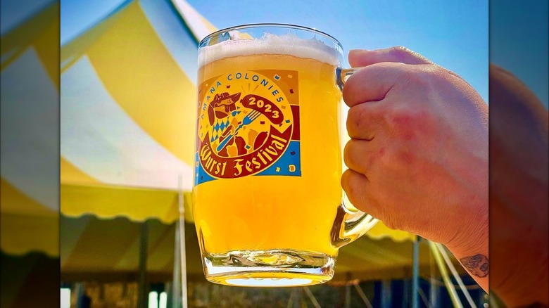 Man holding Amana Colonies beer mug