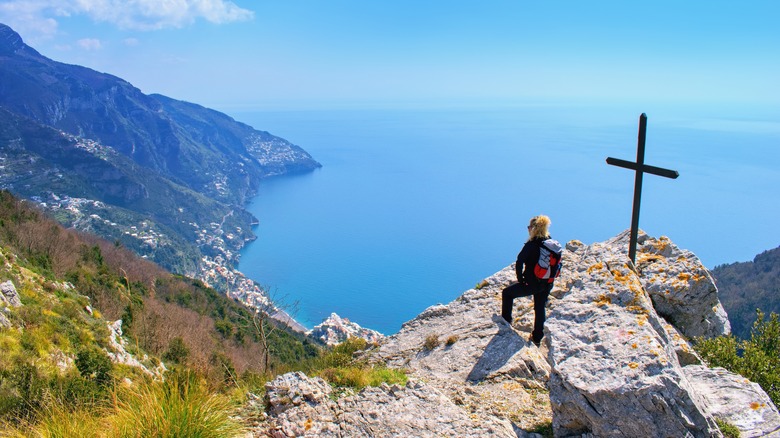 woman on peak on Amalfi Coast near crucifix