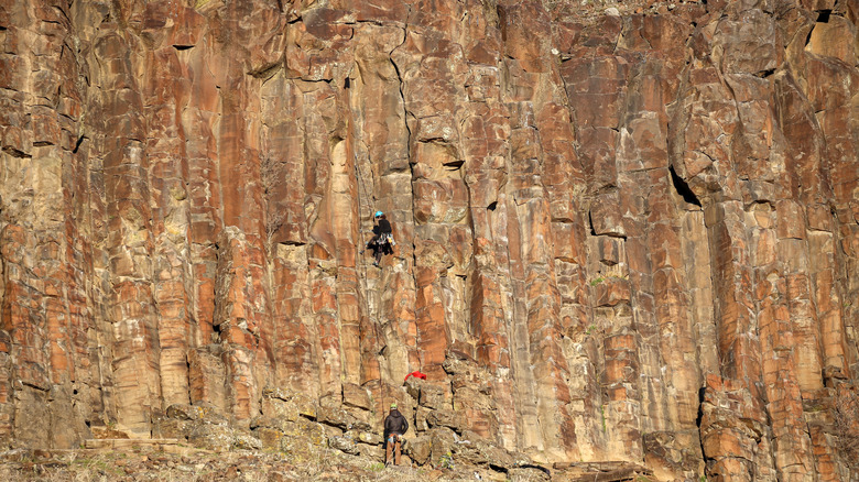 Several people rock climbing at the Black Cliffs in Boise