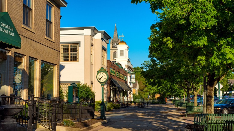 Downtown sidewalk with standing clock and brick buildings in Granville Ohio